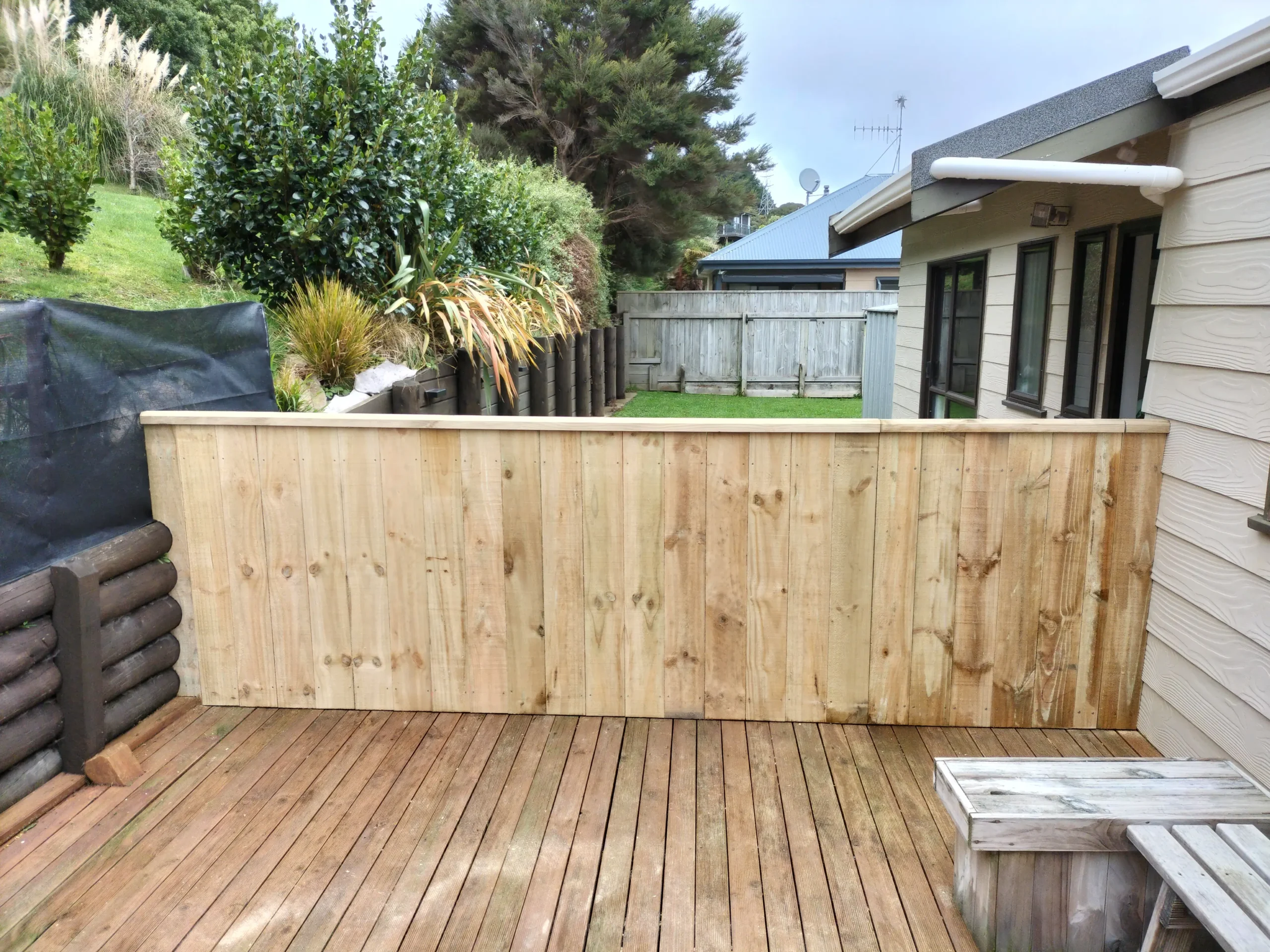 Builders Rodney fencing contractors showcasing a newly built timber privacy fence on a wooden deck.