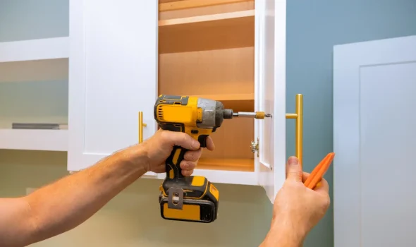 Cabinet handle being installed during kitchen renovations by Builders Rodney team